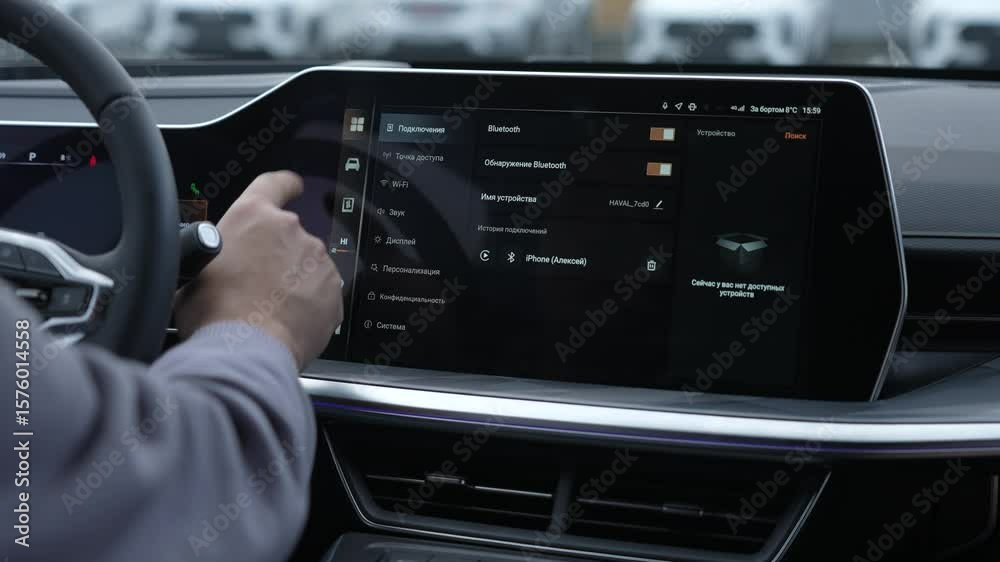 A man uses a touchscreen in a modern car. 