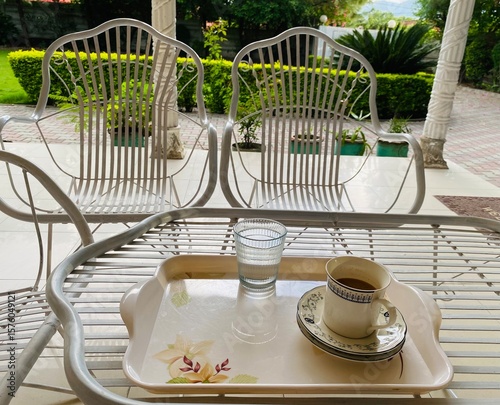 cup of tea, water, table and chairs