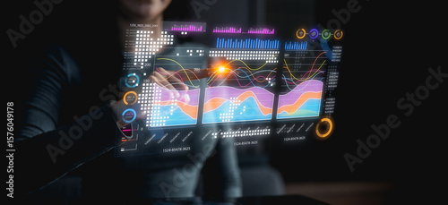 Quadro em tela A person interacts with a futuristic transparent digital interface displaying colorful data charts and analytics in a dark environment