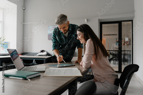 Two coworkers engaging in a productive discussion while working on a project together.
