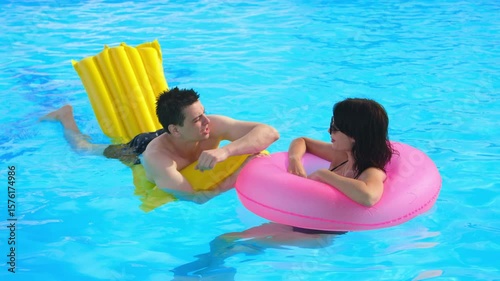 Young couple enjoying a warm summer day in the swimming pool. Concept relaxation, love, summer vibes.