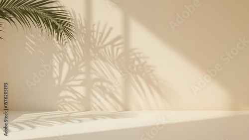 Minimal summer background with natural palm leaf shadow. Pastel colored aesthetic photo with palm plant shadow on the wall and table. Can be used for product presentation.