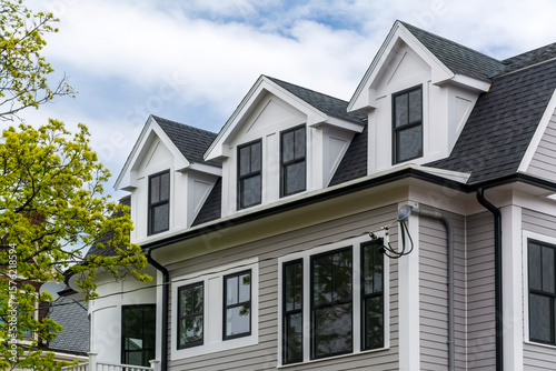 Bild auf Leinwand Contemporary house exterior featuring gray siding and black-framed windows in Br