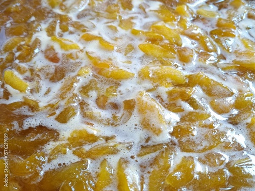Apricot slices in sugar syrup. Food background. Making homemade apricot jam