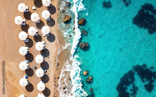 Aerial View White Beach Umbrellas on Sandy Rocky Beach, Waves, Scenic Coastal Shot