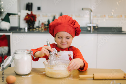 Young chef in red hat baking christmas cookies