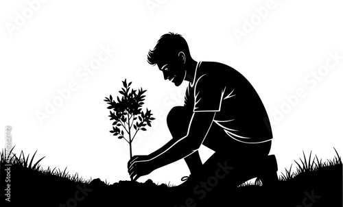 A man kneels to plant a small tree, carefully placing it in the soil