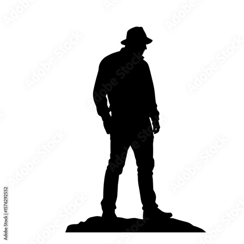 Man standing silently on rocky surface in silhouette  