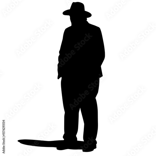 Silhouette of man wearing hat standing with hands in pockets  