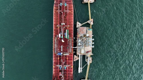 Aerial view oil ship tanker vessel loading and unloading in oil terminal station refinery, Global business import export logistic transport sea freight cargo tanker, Red crude oil tanker ship at port.