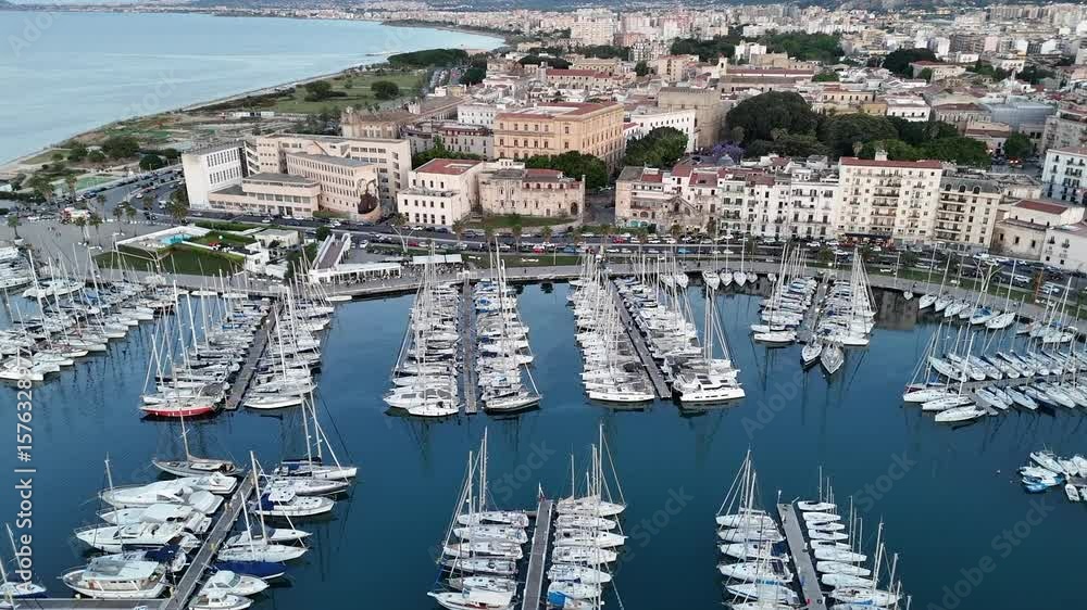 Sorvolo aereo con drone porto turistico darsena con vista barche a vela al tramonto della cala di palermo che evidenziano inquinamento in un paesaggio mozzafiato dello skyline della città antica 