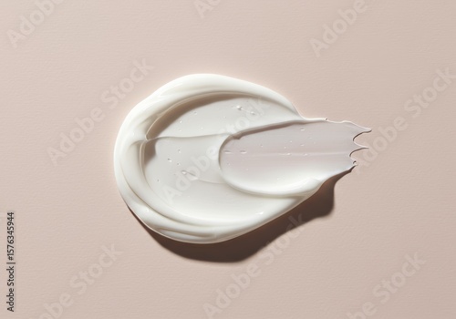 A textured swipe of white cream or lotion on a light beige background, showcasing its smooth and rich consistency. Ideal for skincare, beauty, and cosmetic applications.