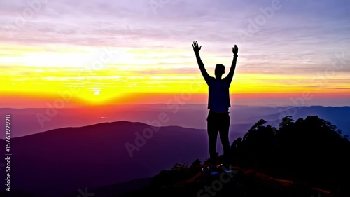 Wallpaper Mural Hiker standing with raised arms on mountain peak, silhouetted against vibrant sunset, experiencing moment of triumph and serenity in vast wilderness landscape Torontodigital.ca