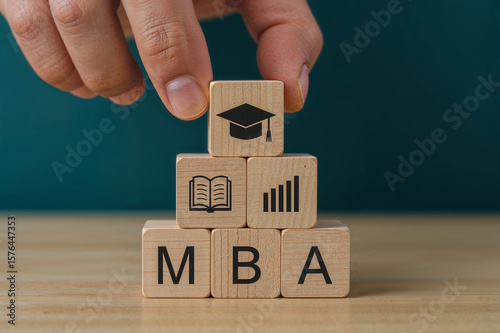 Hand placing graduation cap block on mba cubes representing business education and career growth