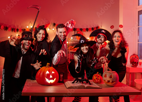 Quadro su tela Group portrait of friends in costume celebrating halloween during night party with pumpkin, showcasing togetherness in a festive setting with focus on holiday fun and lively atmosphere