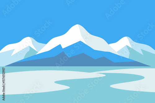 Winter mountain landscape with snow-capped peaks under a blue sky, offering a panoramic view of cold, serene nature