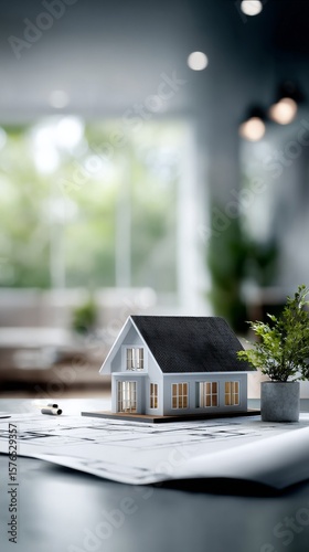 Miniature House Model on Architectural Blueprints in a Modern Workspace With ...