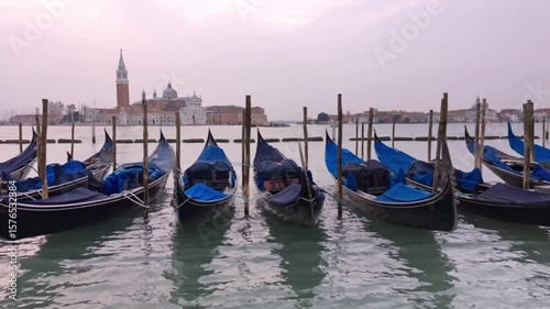 Gondolas lined up in a venetian canal with historic buildings