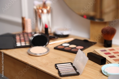 Foto Different makeup products on wooden vanity indoors, closeup