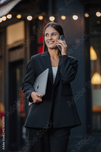 Elegant business woman talking by smartphone in the city