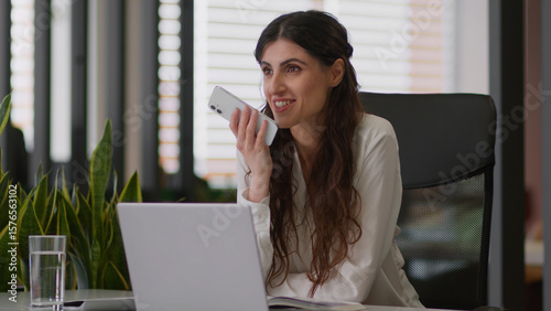 Obraz na plátne Smiling business woman Caucasian girl talk loudspeaker mobile phone speakerphone