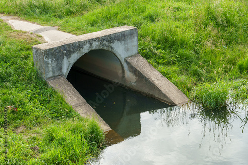 Underground pipes for draining rivers in the city. Discharge of industrial water into a reservoir. A threat to nature.