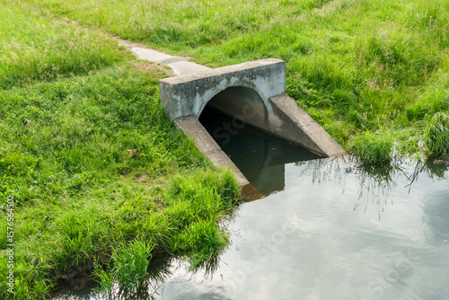 Underground pipes for draining rivers in the city. Discharge of industrial water into a reservoir. A threat to nature.