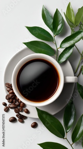 Freshly Brewed Coffee in a White Cup Surrounded by Coffee Beans and Green Leaves