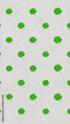 Digital animation of multiple clover leaves moving against irish flag
