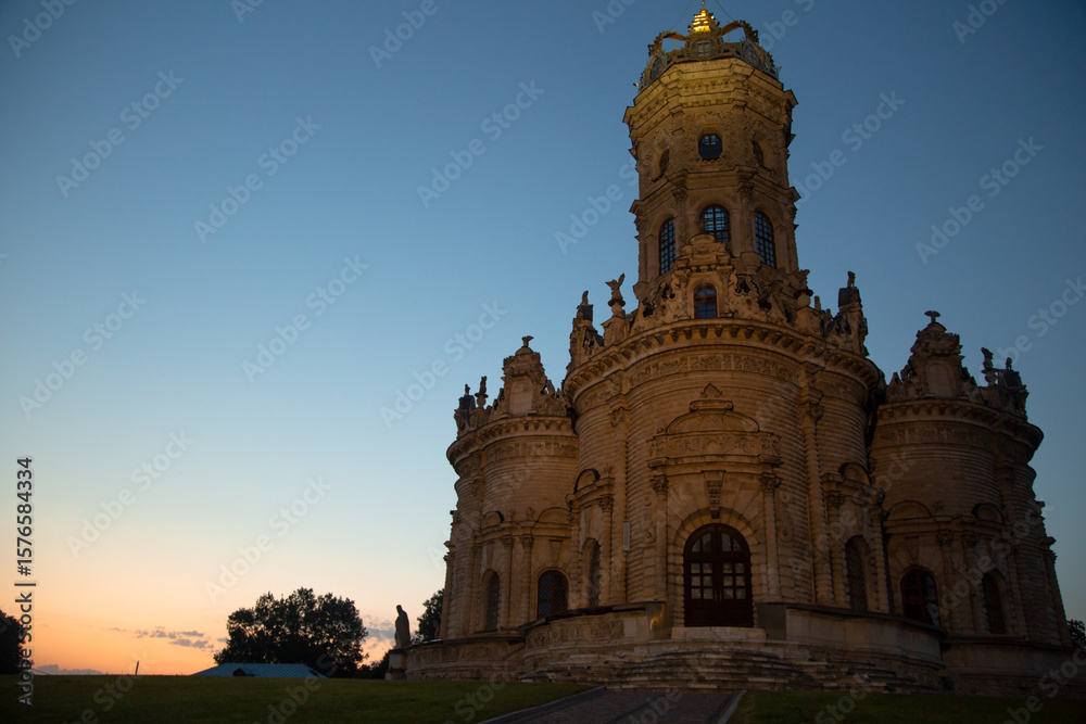 Obraz premium Beautiful entrance door with staircase to baroque medieval style old church building on nature bright evening light on sunset bright blue sky. Europe religion architecture building