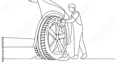 Man washing car tire with soap and water in outdoor setting  