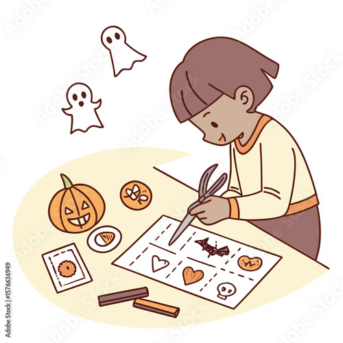 A young child happily cuts out halloween themed shapes from paper including ghosts pumpkins bats hearts and skulls for festive decorations