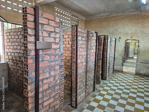 Phnom Penh, Cambodia - 25 June 2025. Narrow brick cells used for solitary confinement are aligned inside a former classroom at Tuol Sleng Genocide Museum, now preserved for historical memory.