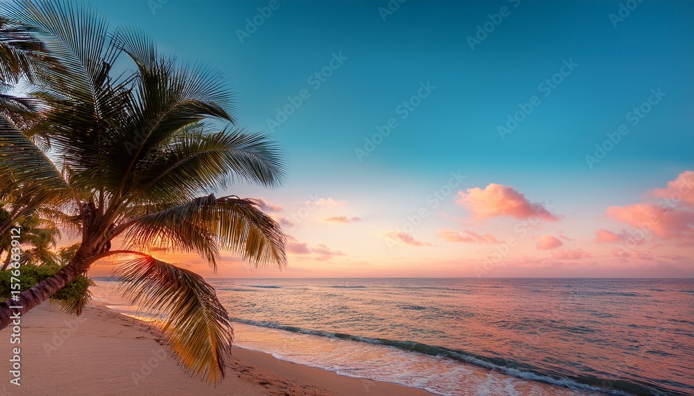 Fototapeta premium sunset and palm trees on the beach against the soft pink tropical sky over the blue pacific ocean water