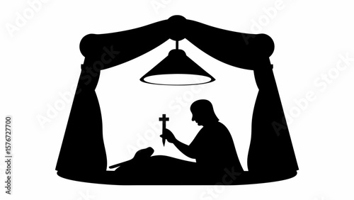 Silhouette of a person holding a cross over a body under a lamp and draped fabric in a dark setting
