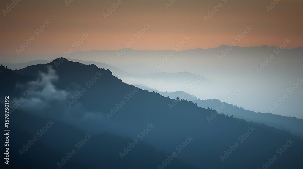 Obraz premium Misty mountain ranges fade into sunrise