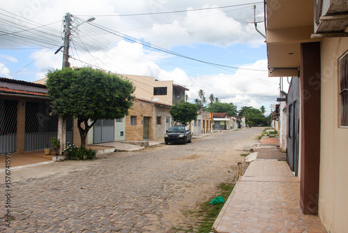 Fototapeta Naklejka Na Ścianę i Meble -  quiet street in small brazilian town, cobblestone residential road with houses, typical urban neighborhood in countryside, Pedro Velho, brazilian city
