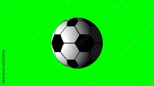 Black and white rotating soccer ball isolated on a green background	