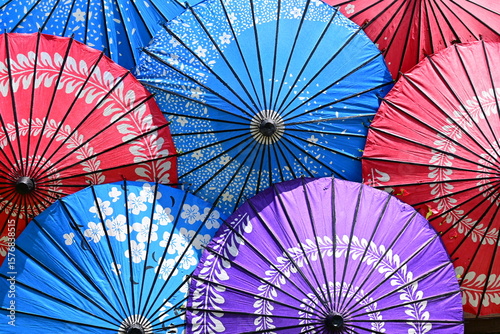 Traditional Asian paper umbrellas, intricate patterns, vivid colors.