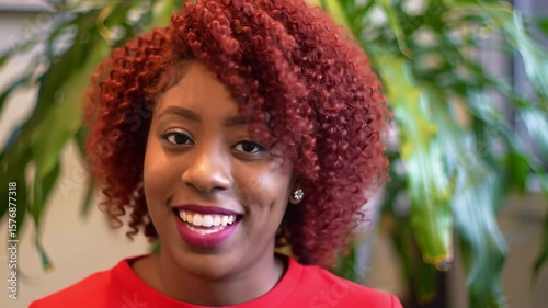 Woman with vibrant red curly hair smiling
