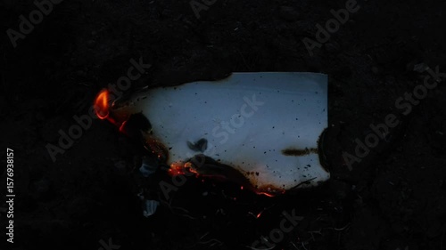 Burning and glowing photo or paper with fire flame and smoke on dark background