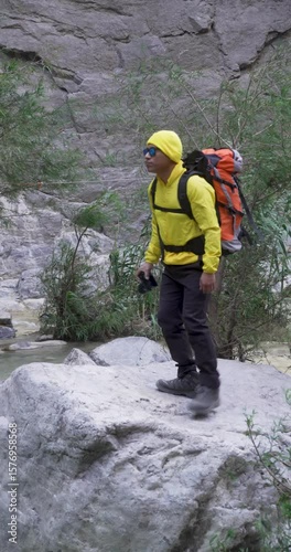 Full shot of a mexican photographer working over a rock into the wild