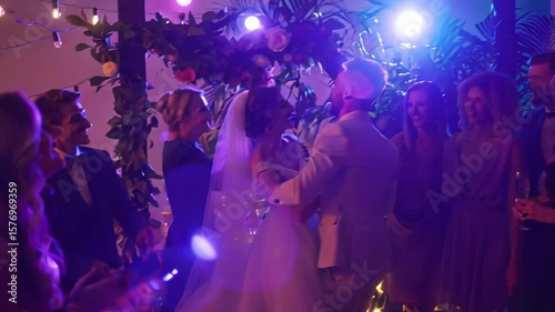 Color‑splashed bridal party cheers around newlyweds, confetti flying and laughter filling vibrant evening reception scene.