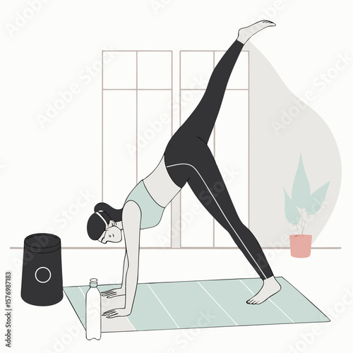 Woman in yoga pose with one leg raised indoors near a water bottle and speaker on a yoga mat near plant