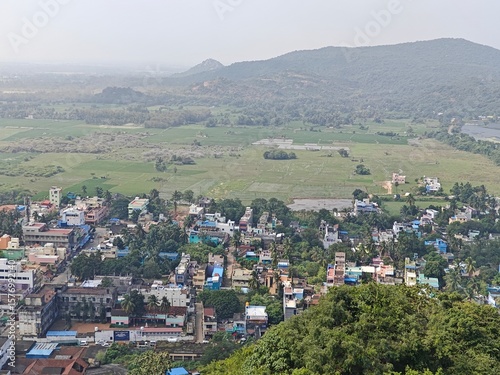 A spiritually resonant view of Thirukazhukundram, Tamil Nadu, India, capturing both the hilltop Vedagiriswarar Temple and the ancient foothill temple complex. The hill temple, dedicated to Lord Shiva,