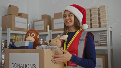 Fotografía Woman organizing donations at charity center wearing santa hat sorting toys in festive indoor setting enhancing volunteer spirit and holiday joy helping community with generous contributions