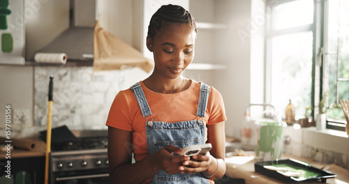 Painting, phone and woman in home for renovation, interior design or chat for diy upgrade. Mobile, remodeling kitchen and happy African person research for house improvement with creative inspiration