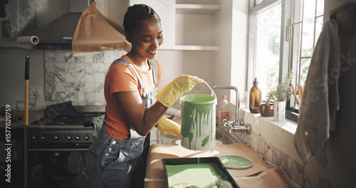 Painting, remodeling and black woman in home with bucket for diy project, renovation and creative decor. Interior design, happy and person with color for kitchen improvement, styling and maintenance