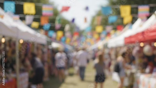 Blurry outdoor market scene with vendor booths and colorful banners