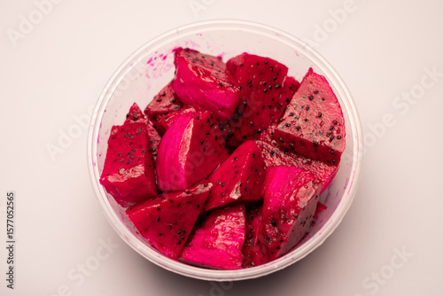 The bright red dragon fruit flesh, with black seeds inside, appears fresh and tempting. Its sweet and refreshing taste makes it a perfect healthy snack or an addition to various tropical dishes.